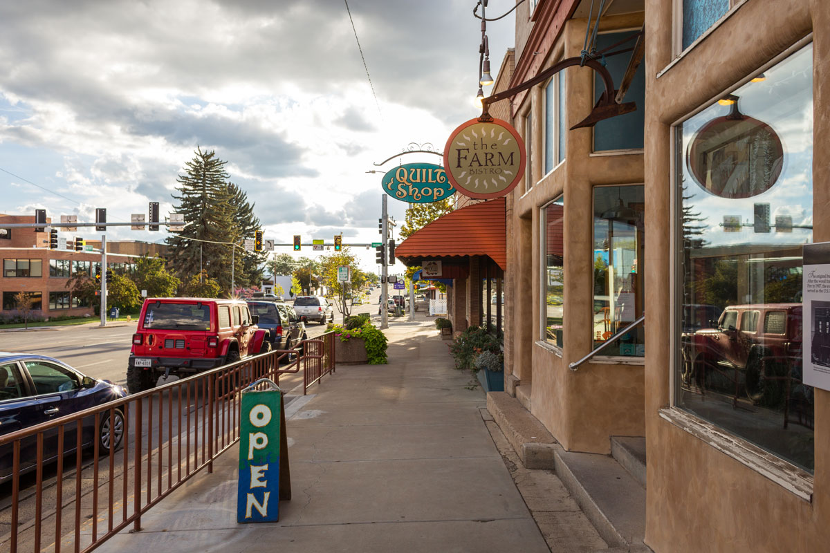 Downtown Cortez, Colorado sidewalk with The Farm Bistro and Quilt Shop signs, gateway to Mesa Verde