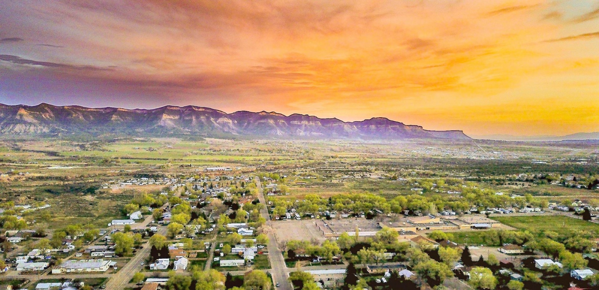 Aerial view of Cortez, Colorado at sunset with mesas in the distance