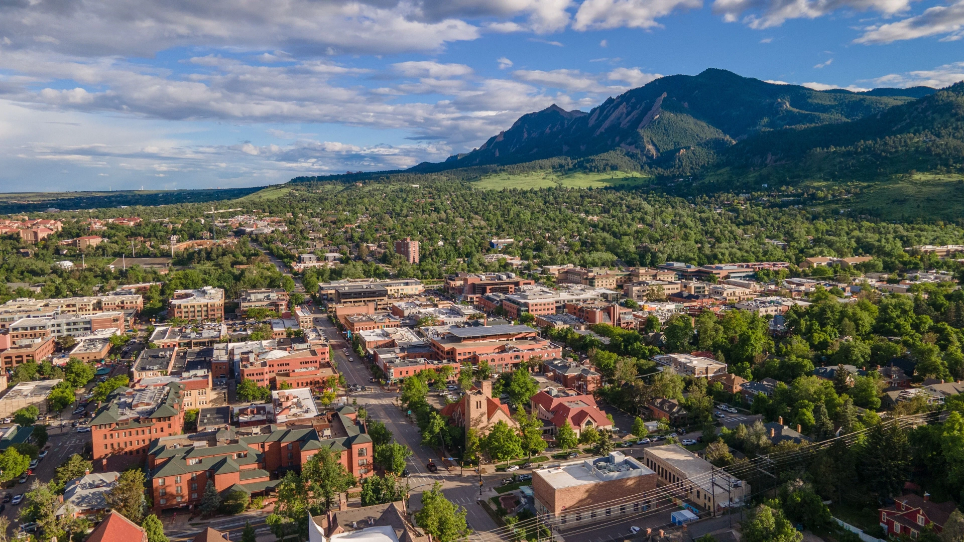 Aerial view of downtown Boulder, Colorado with the Flatirons in the background