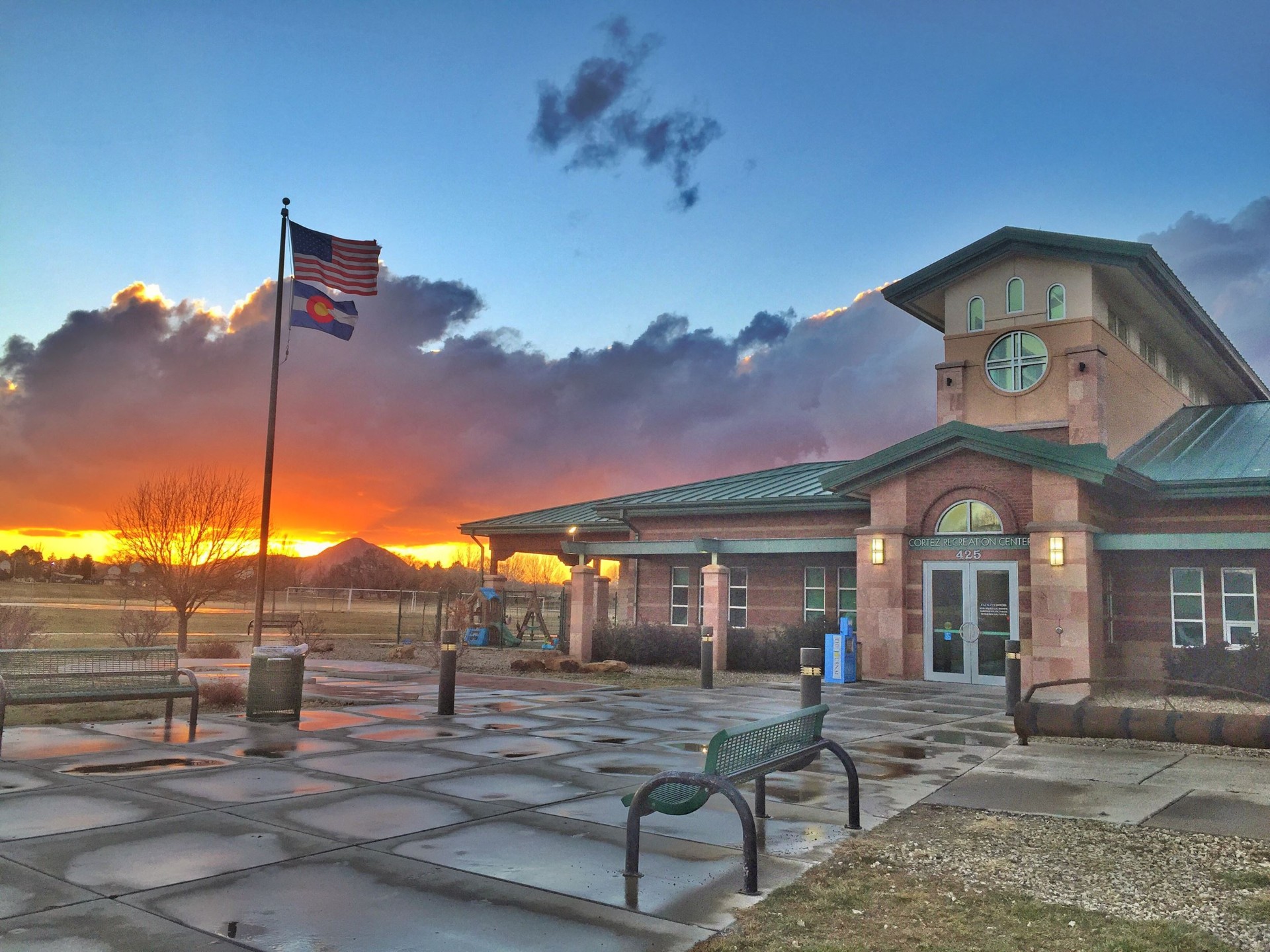 Cortez Recreation Center at sunset with American and Colorado flags