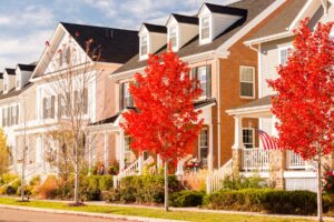 Image of front of homes with trees of red leaves